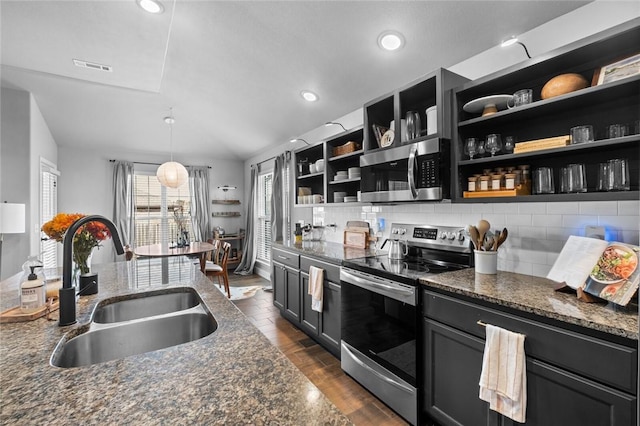 kitchen with stainless steel appliances, sink, and dark stone countertops