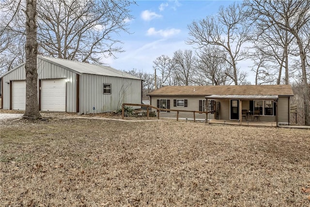 view of front facade featuring a garage, an outbuilding, and covered porch