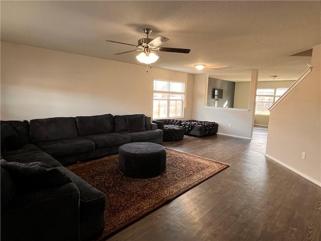 living room with ceiling fan, a textured ceiling, and dark hardwood / wood-style flooring