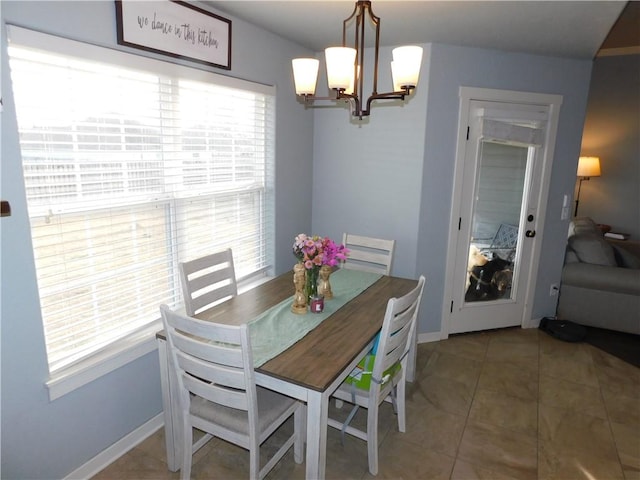 dining area featuring tile patterned flooring and an inviting chandelier