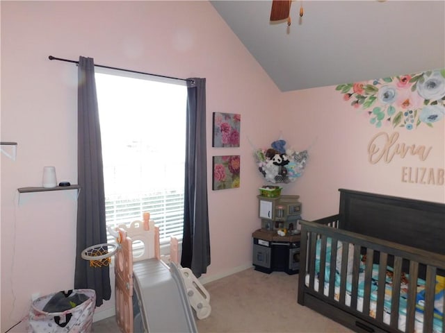 carpeted bedroom featuring ceiling fan, lofted ceiling, and a nursery area