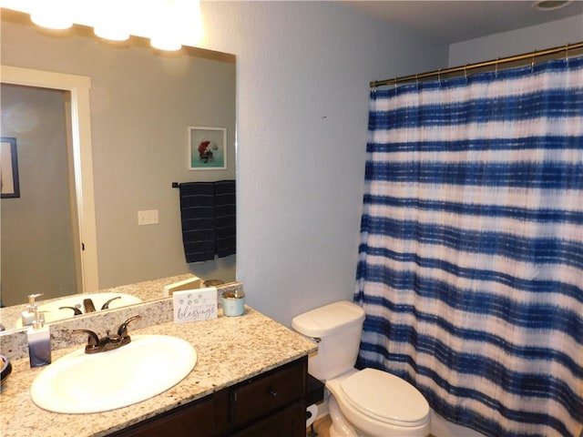 bathroom featuring a shower with shower curtain, vanity, and toilet