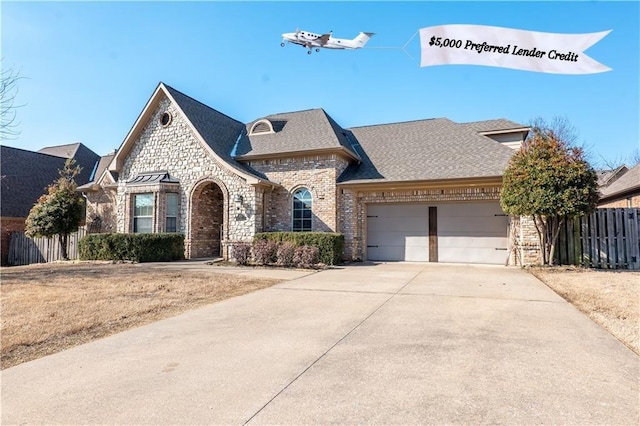 french country style house with brick siding, stone siding, and fence
