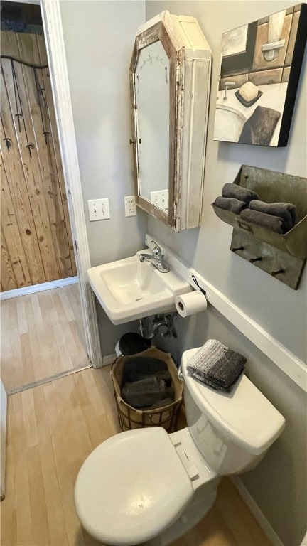 bathroom with sink, toilet, and hardwood / wood-style floors