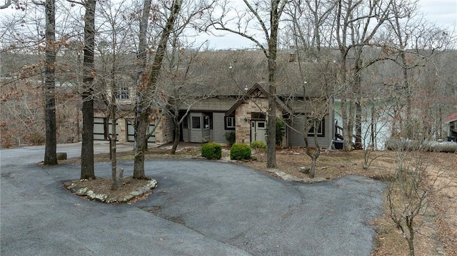 view of front of house featuring driveway and stone siding