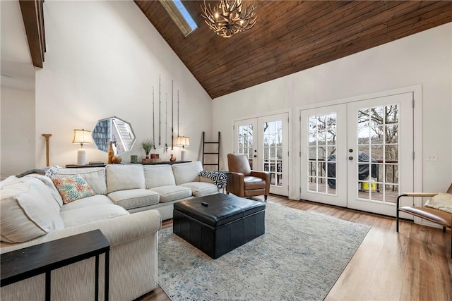 living area with french doors, a chandelier, wood finished floors, high vaulted ceiling, and wooden ceiling