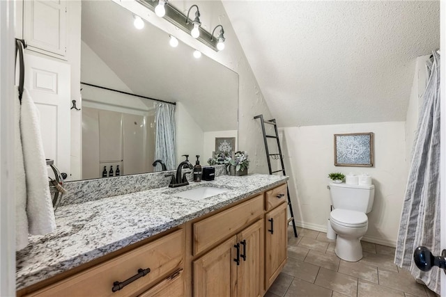 bathroom with lofted ceiling, a textured ceiling, toilet, vanity, and baseboards