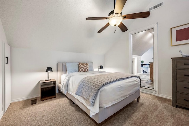 bedroom featuring light colored carpet, visible vents, vaulted ceiling, and a textured ceiling