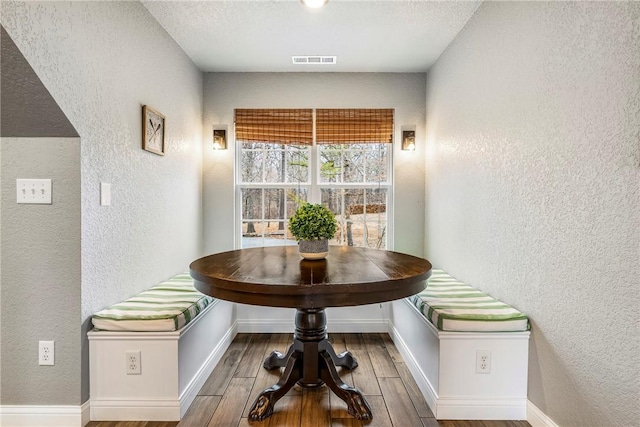 room details featuring visible vents, breakfast area, and a textured wall