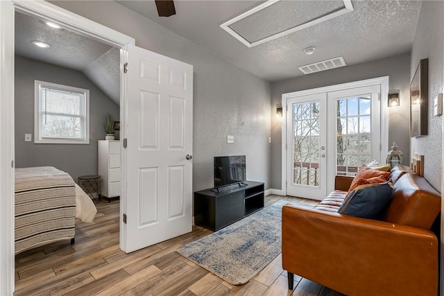 living room with a textured ceiling, visible vents, and a healthy amount of sunlight