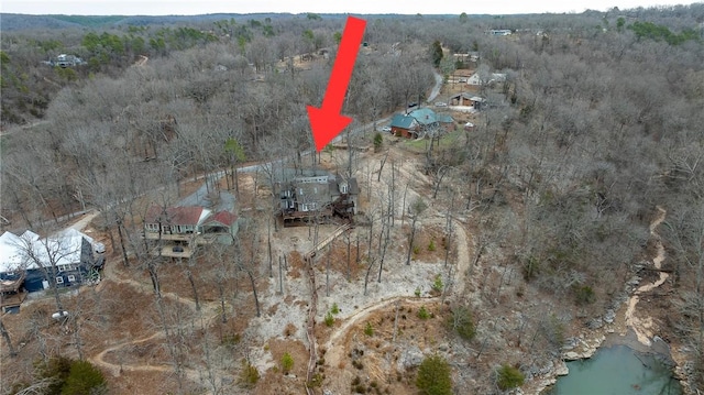 drone / aerial view with a water view and a wooded view