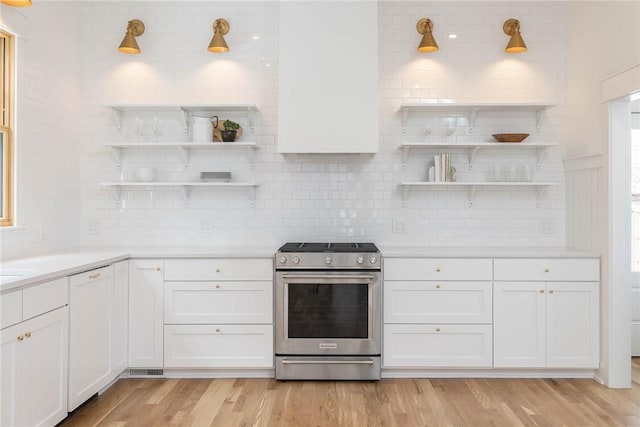 kitchen featuring stainless steel stove, light hardwood / wood-style floors, and white cabinets