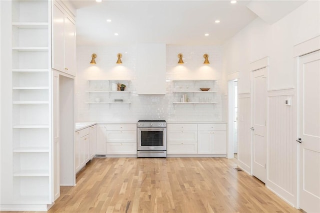 kitchen with open shelves, stainless steel electric stove, light countertops, and white cabinets