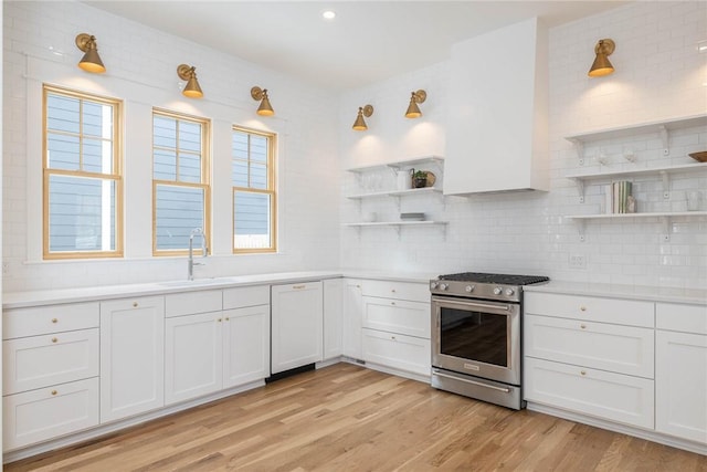 kitchen featuring open shelves, stainless steel gas stove, a sink, and backsplash