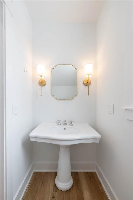 bathroom with baseboards and wood finished floors