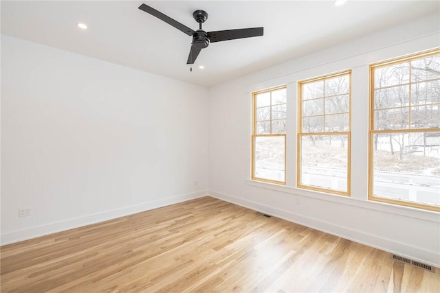 empty room featuring baseboards, light wood-style flooring, visible vents, and ceiling fan