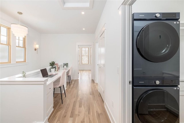 washroom with recessed lighting, stacked washing maching and dryer, light wood finished floors, and baseboards