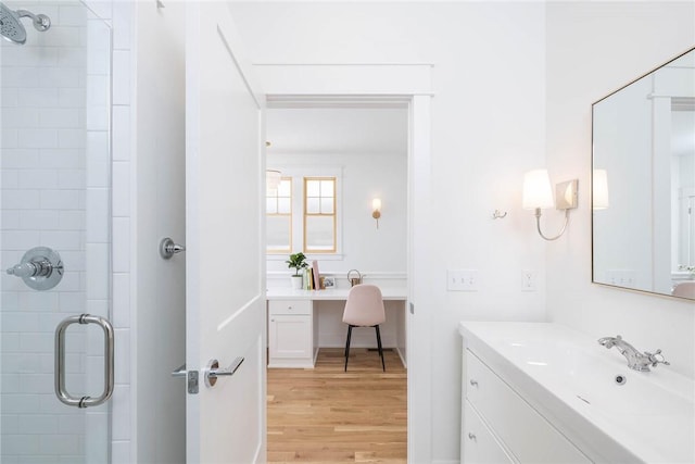 bathroom with a shower stall, vanity, and wood finished floors