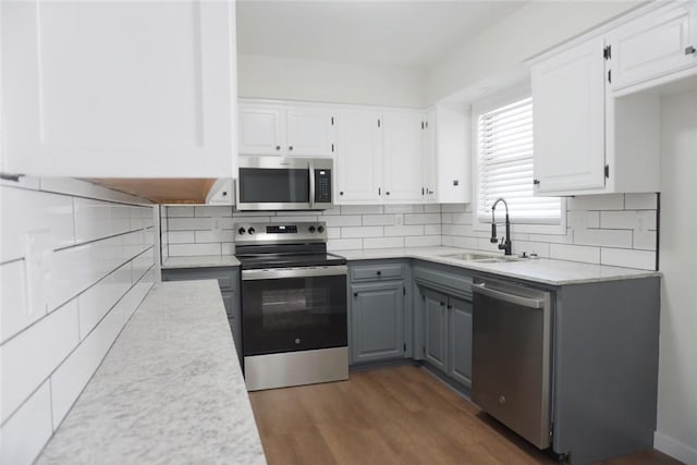 kitchen featuring sink, gray cabinetry, stainless steel appliances, dark hardwood / wood-style flooring, and white cabinets