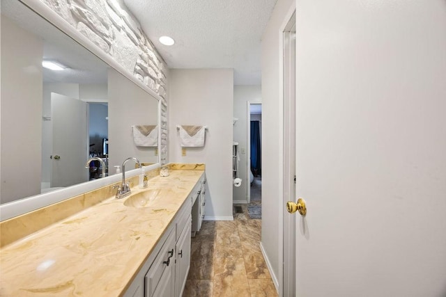 bathroom with a textured ceiling and vanity