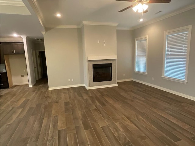 unfurnished living room with ceiling fan, ornamental molding, and dark hardwood / wood-style flooring