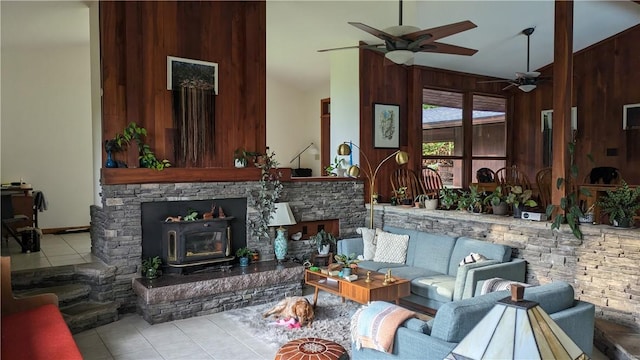 living area featuring wood walls, ceiling fan, a high ceiling, and tile patterned floors