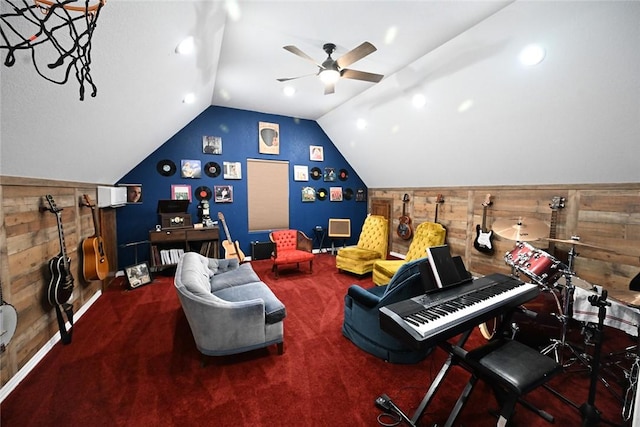 interior space featuring carpet flooring, vaulted ceiling, wooden walls, and ceiling fan