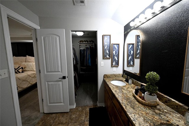 bathroom featuring lofted ceiling and vanity