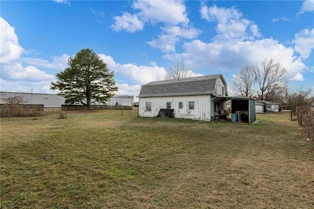 back of property featuring a yard and an outbuilding