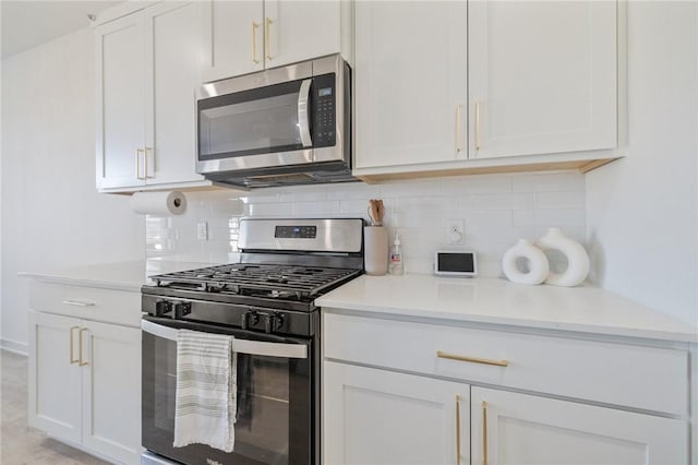 kitchen with white cabinets, tasteful backsplash, stainless steel appliances, and light stone counters