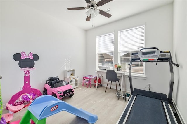 exercise room featuring light hardwood / wood-style flooring and ceiling fan