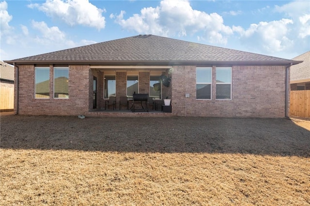 rear view of property with a yard and a patio area