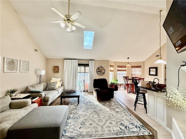 tiled living room featuring ceiling fan and high vaulted ceiling