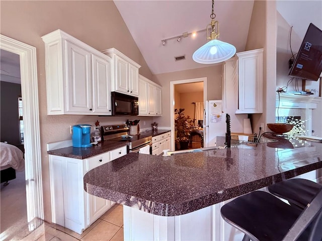 kitchen featuring a breakfast bar area, stainless steel range with electric cooktop, white fridge, white cabinetry, and kitchen peninsula