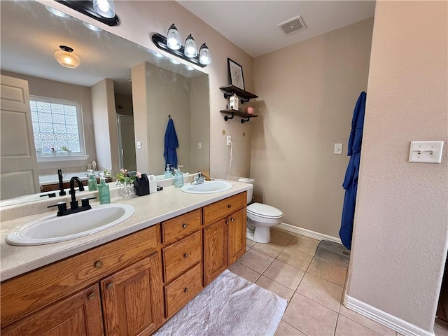 bathroom featuring toilet, tile patterned flooring, vanity, and a shower with door