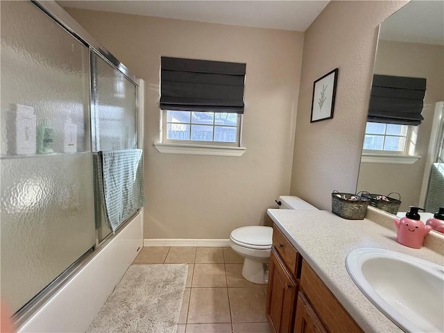 full bathroom featuring shower / bath combination with glass door, tile patterned flooring, vanity, and a wealth of natural light