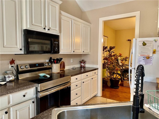 5 Ventnor Dr, Bella Vista, AR 72715 - kitchen featuring black microwave, stainless steel range with electric cooktop, dark countertops, and white cabinetry