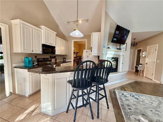 5 Ventnor Dr, Bella Vista, AR 72715 - kitchen with black microwave, electric range, freestanding refrigerator, lofted ceiling, and a breakfast bar