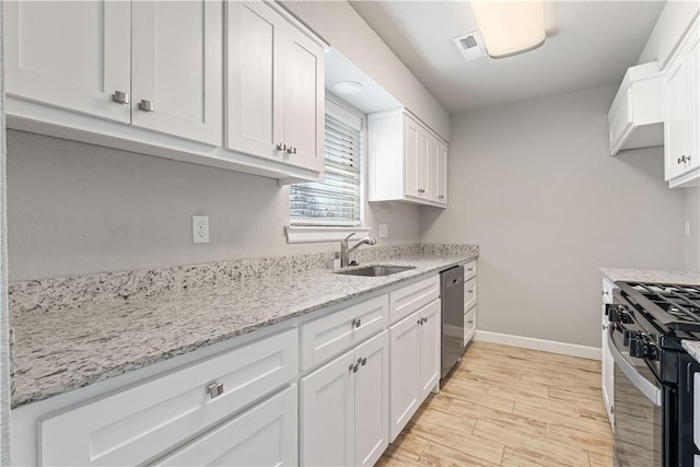 kitchen featuring stainless steel dishwasher, gas range oven, sink, and white cabinetry