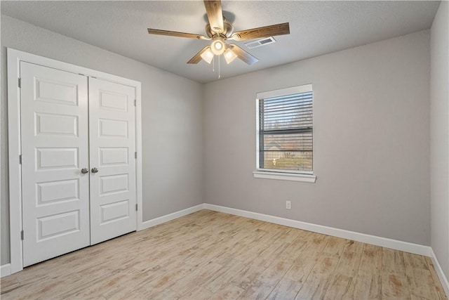 unfurnished room featuring a textured ceiling, ceiling fan, and light hardwood / wood-style flooring