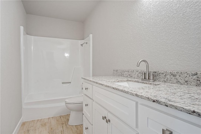 full bathroom with bathtub / shower combination, toilet, vanity, and hardwood / wood-style floors