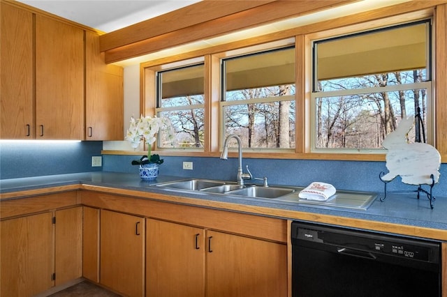 kitchen with dishwasher, dark countertops, a sink, and brown cabinets