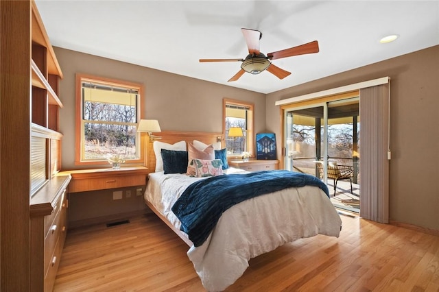 bedroom with light wood-style floors, access to outside, visible vents, and a ceiling fan