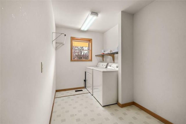 clothes washing area featuring laundry area, baseboards, light floors, and separate washer and dryer