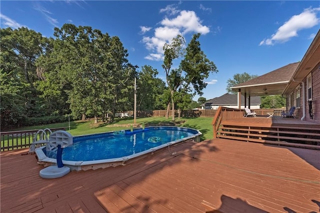 view of swimming pool with a yard and a deck