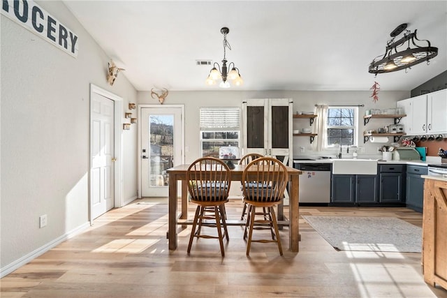 dining area with an inviting chandelier, light hardwood / wood-style floors, and lofted ceiling