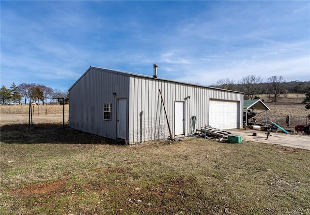 view of outbuilding featuring a garage and a lawn