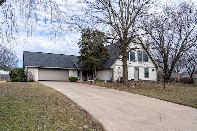 view of front facade featuring a garage, concrete driveway, a front lawn, and a shingled roof