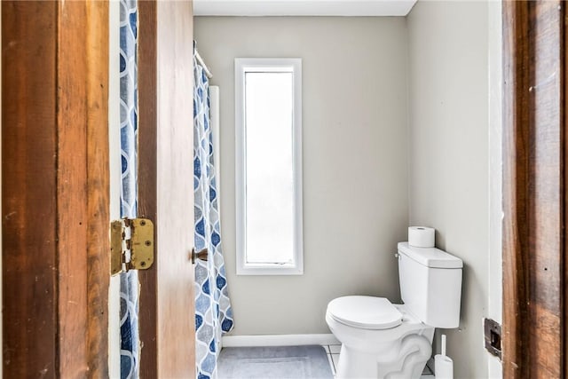 full bath featuring toilet, baseboards, and tile patterned floors