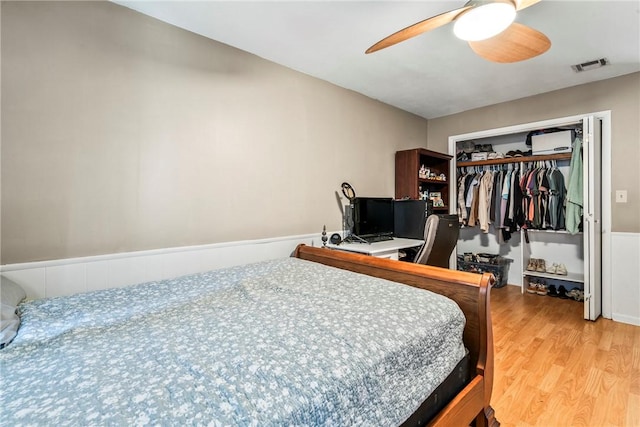 bedroom featuring a ceiling fan, light wood-style flooring, visible vents, and a closet